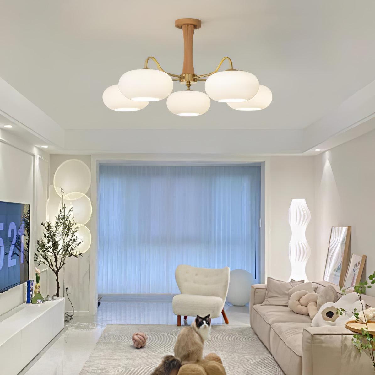 Żyrandol z mosiężnymi ramionami i białymi kloszami