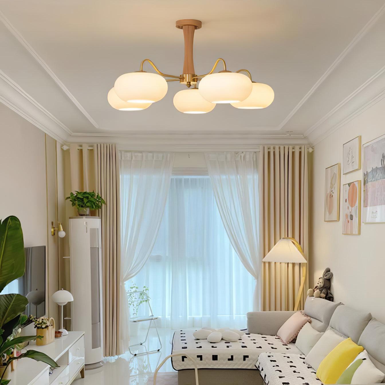 Żyrandol z mosiężnymi ramionami i białymi kloszami